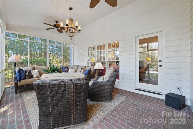 sunroom / solarium featuring ceiling fan with notable chandelier