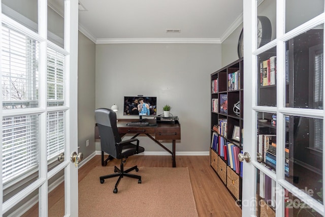 home office with hardwood / wood-style floors, ornamental molding, and french doors