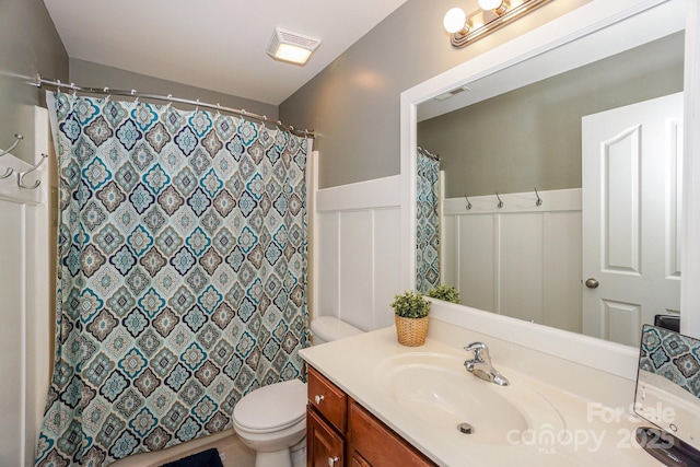 bathroom with vanity, curtained shower, and toilet