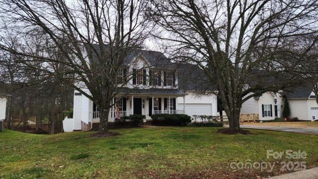 colonial home with a garage and a front lawn