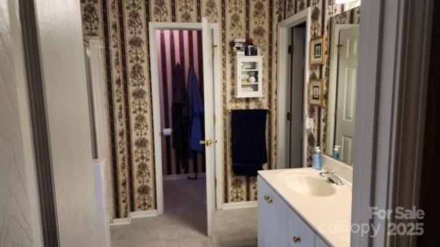 bathroom featuring walk in shower and vanity