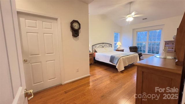 bedroom with vaulted ceiling, ceiling fan, and light hardwood / wood-style floors