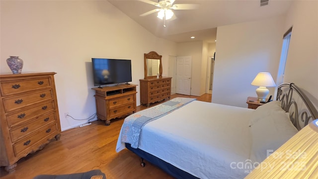 bedroom with vaulted ceiling, ceiling fan, and light wood-type flooring