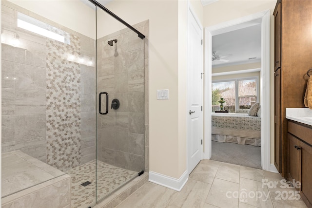 bathroom featuring ceiling fan, tile patterned floors, a shower with shower door, and vanity