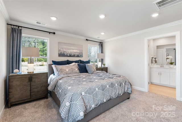 carpeted bedroom featuring multiple windows, sink, ornamental molding, and ensuite bathroom