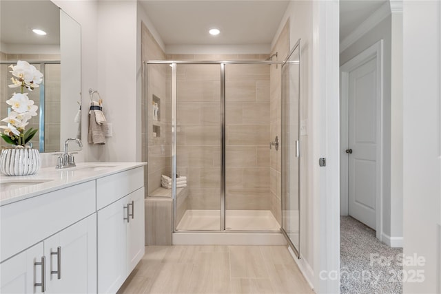 bathroom featuring vanity, ornamental molding, and a shower with door