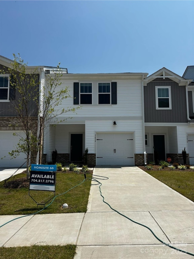 5054 Kellaher Pl, Charlotte, NC 28216 - view of front of property featuring brick siding, a garage, driveway, board and batten siding, and a front yard