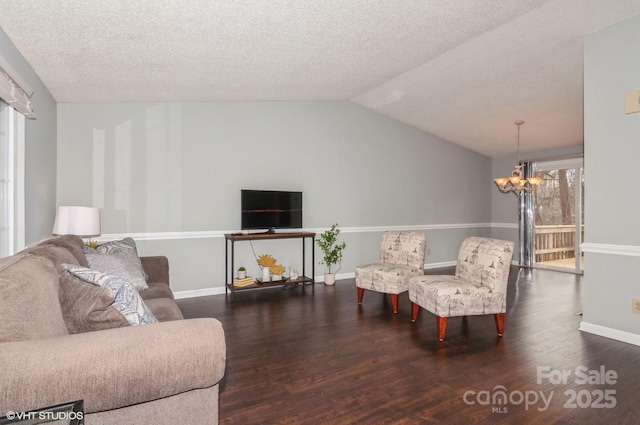 living room with an inviting chandelier, vaulted ceiling, dark hardwood / wood-style floors, and a textured ceiling