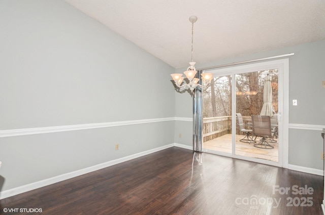 unfurnished dining area with lofted ceiling, a notable chandelier, and dark hardwood / wood-style flooring