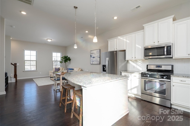 kitchen with white cabinetry, stainless steel appliances, and a center island