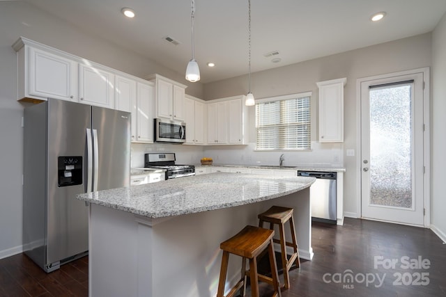 kitchen featuring sink, white cabinetry, appliances with stainless steel finishes, and a kitchen island