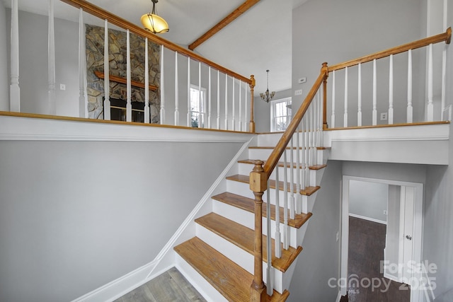 staircase featuring a high ceiling and hardwood / wood-style floors