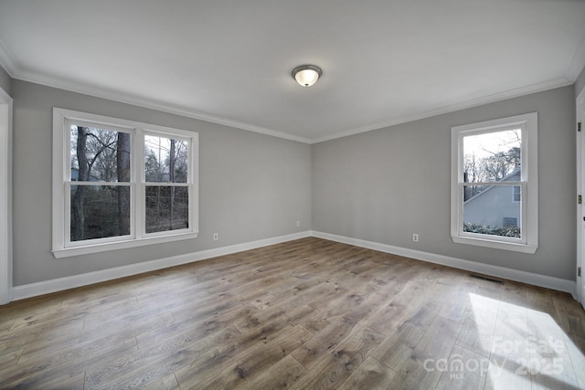 spare room featuring crown molding and light wood-type flooring