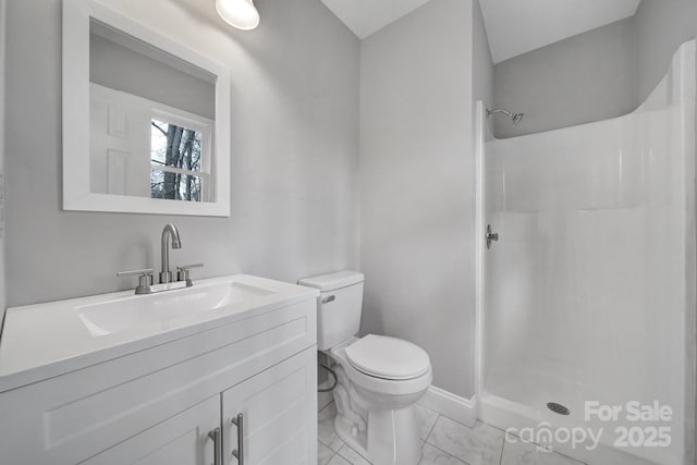 bathroom featuring a shower, vanity, and toilet