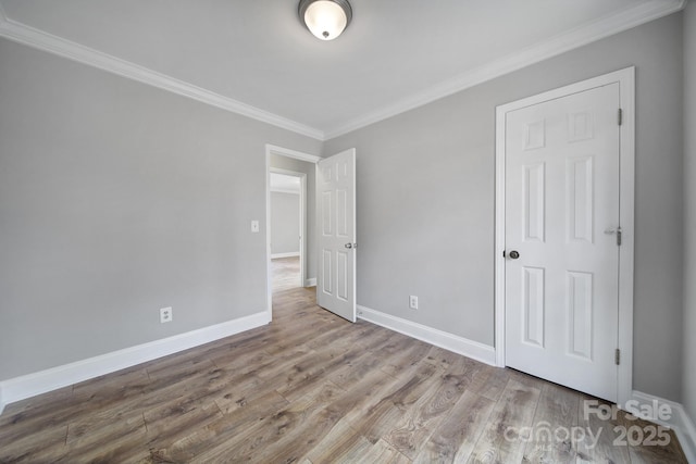 unfurnished bedroom with crown molding and wood-type flooring