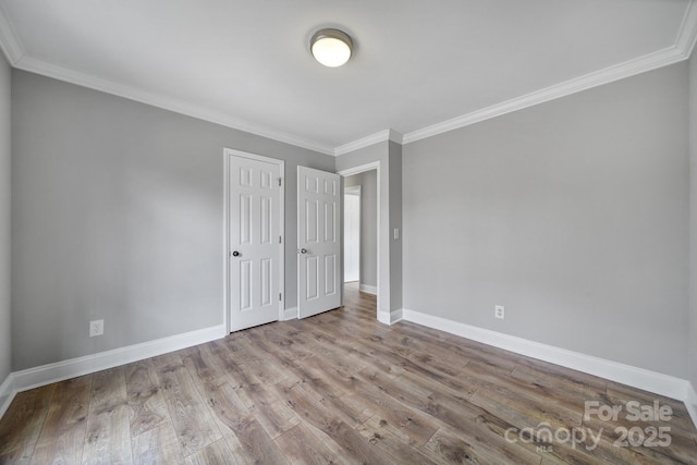 empty room featuring ornamental molding and light hardwood / wood-style flooring