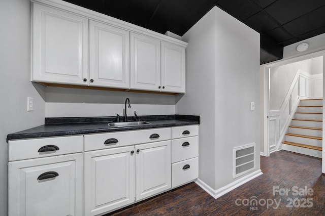 kitchen with dark wood-type flooring, sink, and white cabinets