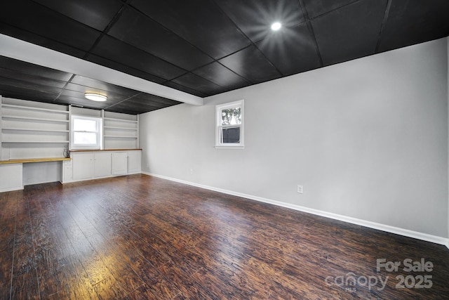 interior space with dark hardwood / wood-style flooring, built in shelves, and built in desk