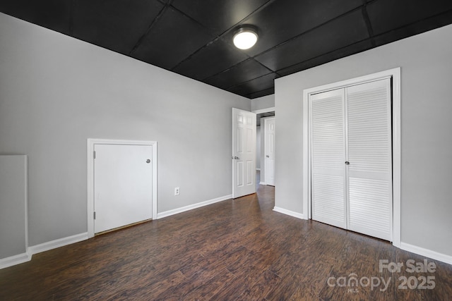 unfurnished bedroom featuring dark hardwood / wood-style floors and a closet