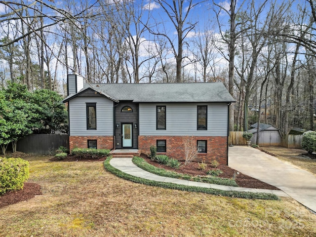 raised ranch featuring a shed and a front yard