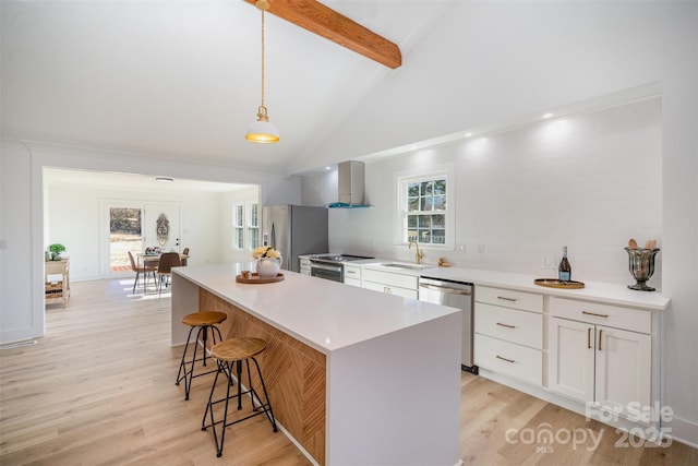 kitchen featuring a kitchen island, white cabinetry, stainless steel appliances, hanging light fixtures, and beam ceiling