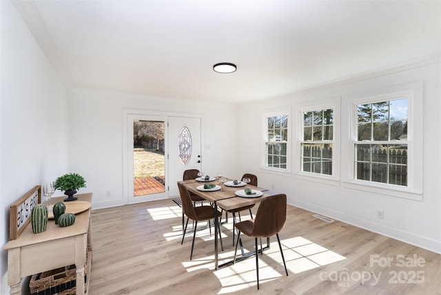 dining area featuring light hardwood / wood-style flooring and ornamental molding