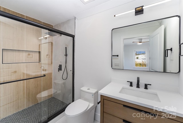 bathroom with toilet, an enclosed shower, ceiling fan, and vanity