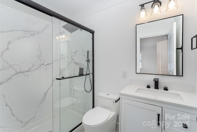 bathroom featuring vanity, a shower with shower door, and toilet