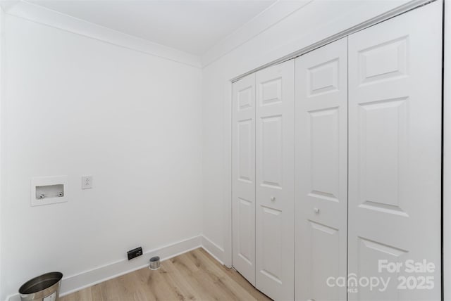 clothes washing area with washer hookup, crown molding, and light wood-type flooring