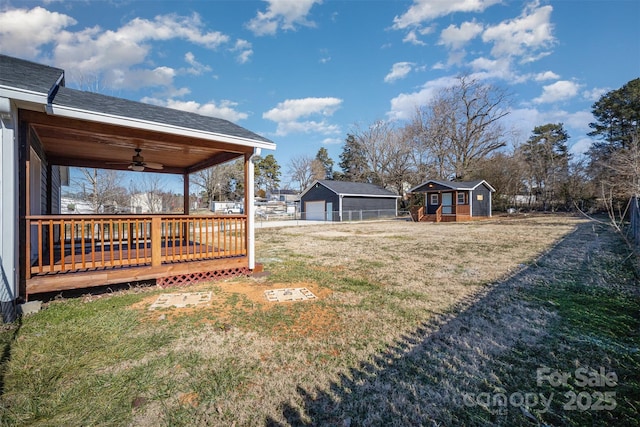 view of yard featuring ceiling fan, a deck, and a storage unit