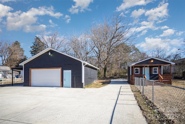 exterior space with a porch, a garage, and an outbuilding