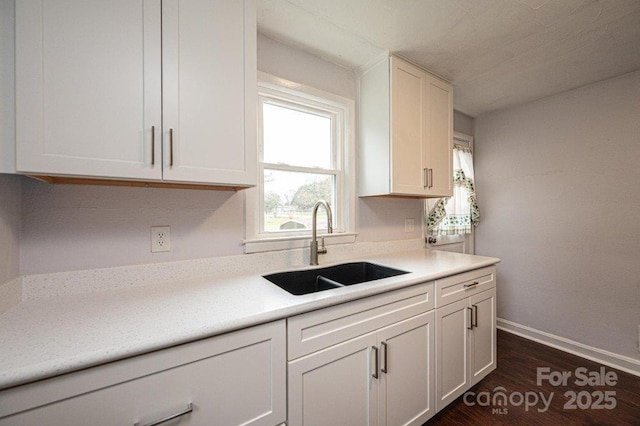 kitchen featuring dark hardwood / wood-style floors, sink, and white cabinetry