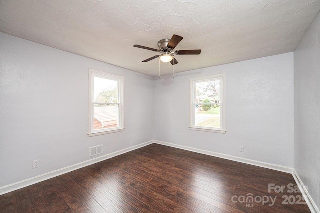 spare room featuring dark wood-type flooring and ceiling fan