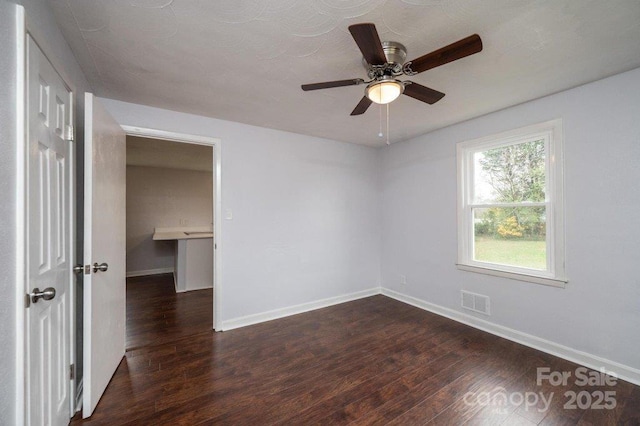 unfurnished room with dark wood-type flooring and ceiling fan