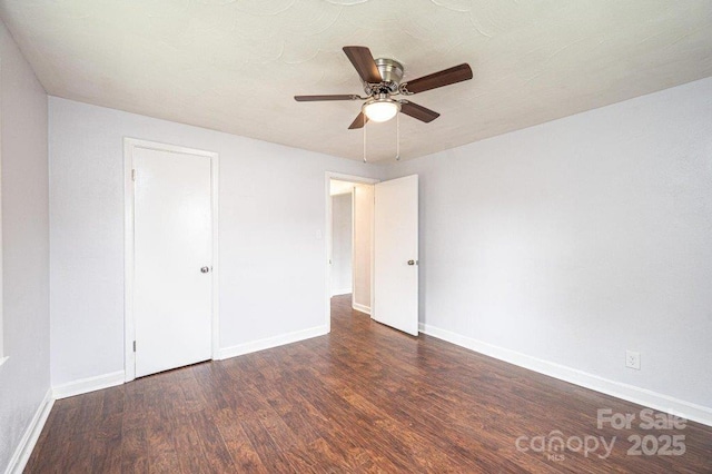 unfurnished bedroom with ceiling fan and dark wood-type flooring