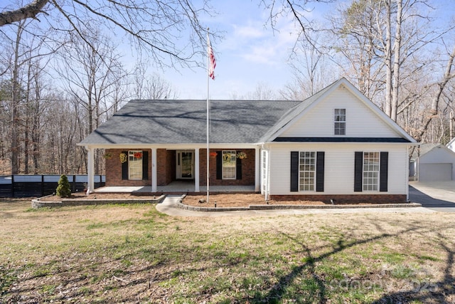 view of front facade with a porch, brick siding, and a front lawn