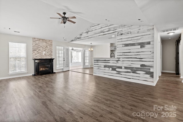 unfurnished living room with dark wood-style flooring, visible vents, a fireplace, and ceiling fan with notable chandelier