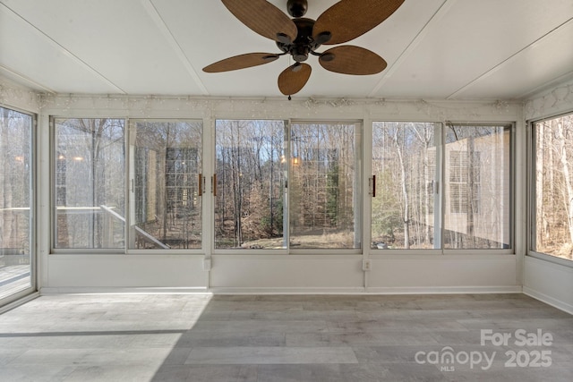 unfurnished sunroom with ceiling fan and plenty of natural light