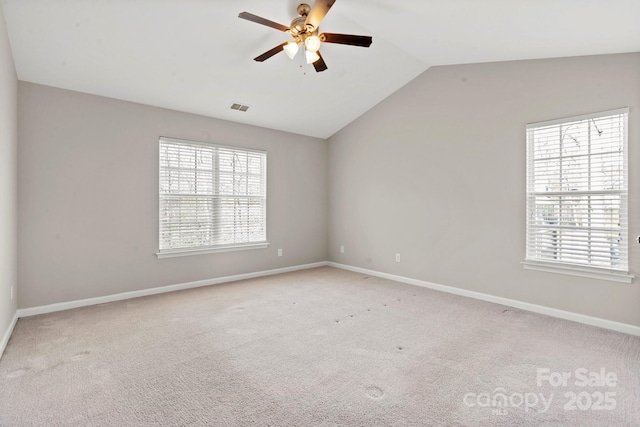 empty room with lofted ceiling, light carpet, visible vents, and a healthy amount of sunlight