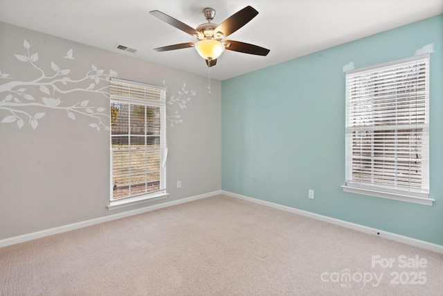 empty room featuring carpet, visible vents, and baseboards