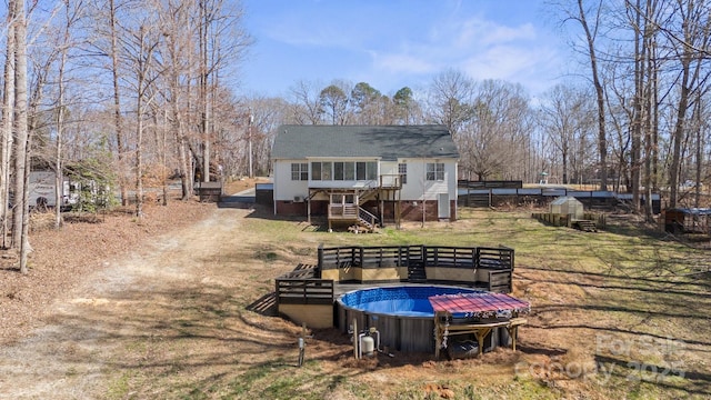 rear view of house featuring stairway and an outdoor pool