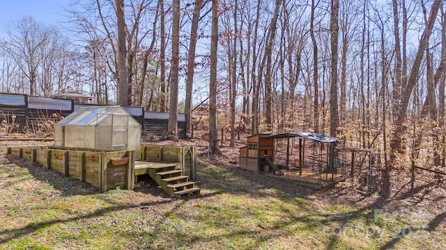 view of yard with an outbuilding and a greenhouse