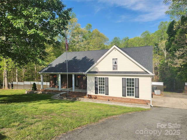 view of front of house with a front lawn and roof with shingles