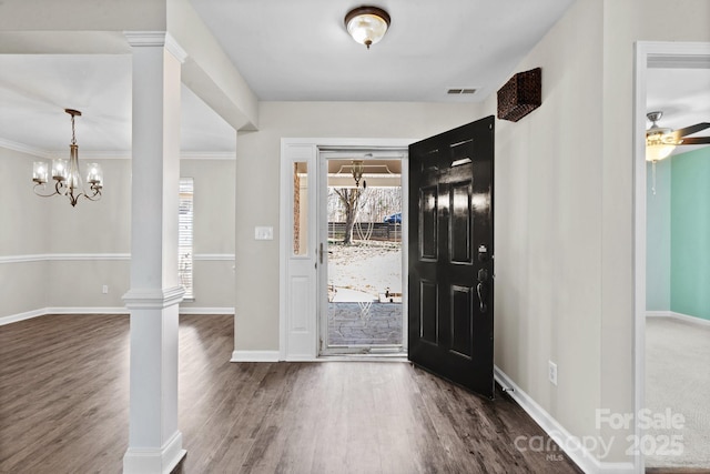 foyer entrance with ornate columns, a healthy amount of sunlight, wood finished floors, and visible vents