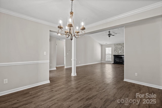 unfurnished living room featuring dark wood-style flooring, baseboards, ornamental molding, a large fireplace, and ceiling fan with notable chandelier