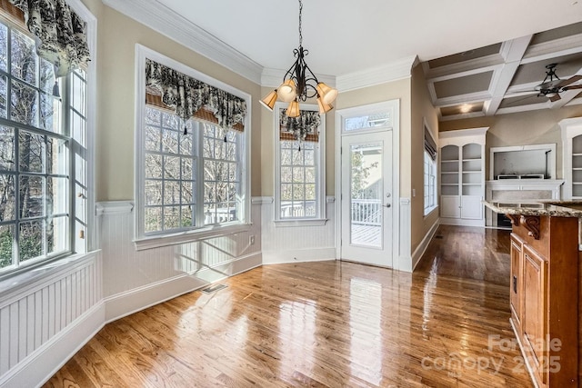 unfurnished dining area featuring a wealth of natural light, crown molding, beamed ceiling, and coffered ceiling