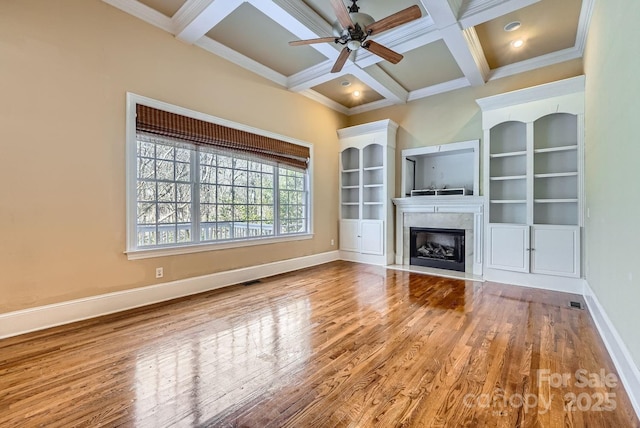 unfurnished living room featuring coffered ceiling, ceiling fan, beam ceiling, and wood-type flooring