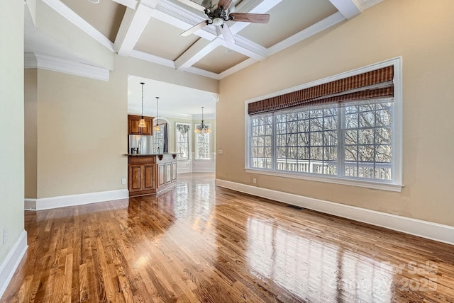 unfurnished living room with ceiling fan with notable chandelier, hardwood / wood-style floors, beamed ceiling, crown molding, and coffered ceiling