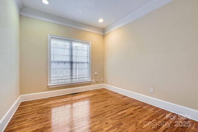 empty room with crown molding and hardwood / wood-style flooring