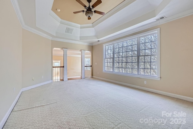 carpeted empty room featuring decorative columns, ornamental molding, a raised ceiling, and ceiling fan